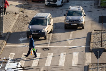 Timisoara, Rumänien - 20. Dezember 2021: Mann überquert Straße. Echte Menschen.