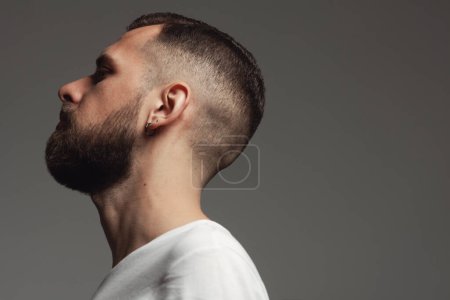Photo for Male beauty concept. Profile portrait of proud charismatic active 30-year-old man posing over dark gray background. Perfect haircut. Hipster style. Close up. Copy-space. Studio shot - Royalty Free Image