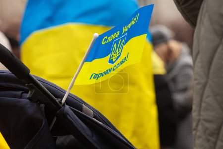 Photo for Dublin, Co.Dublin, Ireland - February 24th 2023 - Ukrainians and supporters rally. The first anniversary of Russia's invasion of Ukraine. O'Connell st near GPO. Close up of flag fixed on baby carriage - Royalty Free Image