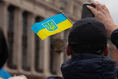 Photo for Dublin, Co. Dublin, Ireland - February 24th 2023 - Ukrainians and supporters rally. The first anniversary of Russia's invasion of Ukraine. O'Connell street near GPO. Man using mobile photo for shooting - Royalty Free Image