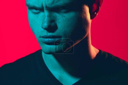 Photo for Male fashion concept. Emotional pop-art portrait of young man wearing black t-shirt over pink background. Avant-garde, retro style. Close up. Studio shot - Royalty Free Image