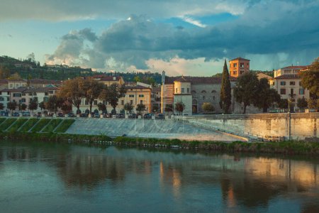 Téléchargez les photos : Concept de Vérone équitable. Vue sur la rivière Adige et la Passeggiata di San Giorgio depuis le Ponte Pietra dans le vieux centre-ville. Ciel nuageux dramatique. Plan extérieur - en image libre de droit