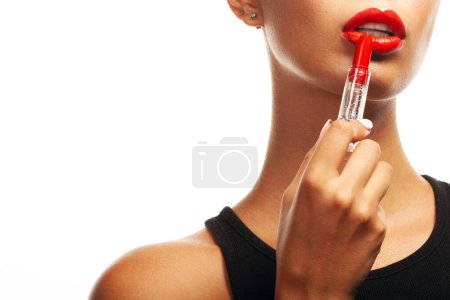 Photo for Red Obsession concept. Close up portrait of charming young woman with opened lipstick in her hand. Healthy skin. Natural make-up. Copy-space. Studio shot - Royalty Free Image