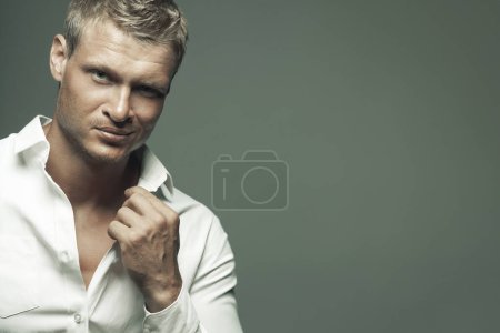 Photo for Male fashion, beauty concept. Portrait of brutal young man with short wet blond hair wearing white shirt, posing over gray background. Classic style. Close up. Copy-space. Studio shot - Royalty Free Image