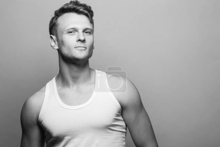 Photo for Male beauty, boy next door concept. Portrait of proud smiling 30-year-old man standing over gray background. Close up. Copy-space. Fashion style. Wavy glossy blond hair. Studio shot - Royalty Free Image