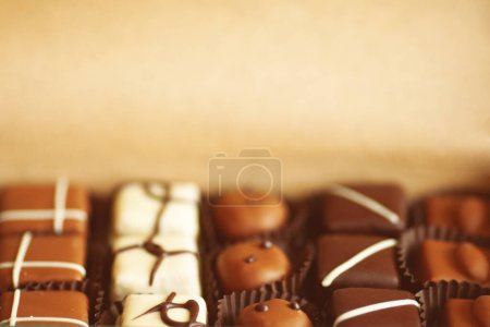 Téléchargez les photos : Doux concept actuel. Un ensemble de bonbons au chocolat faits à la main dans une boîte en papier artisanal. Ferme là. Espace texte. Plan intérieur - en image libre de droit
