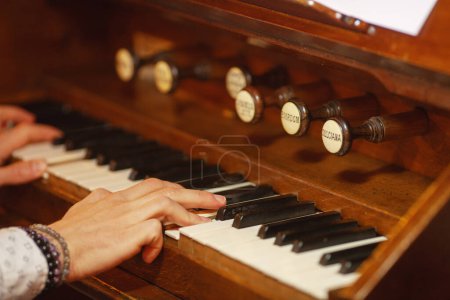 Photo for Young man playing the old organ in Irish church. Close up. Indoor shot - Royalty Free Image