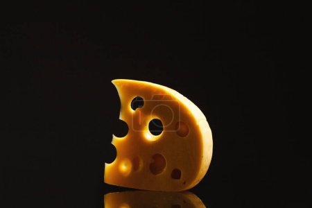 Téléchargez les photos : Concept de produit laitier. Morceau de fromage européen en forme de croissant de lune couché sur miroir sur fond noir symbolisant l'espace extérieur. Style surréaliste et abstrait. Espace de copie. Plan studio - en image libre de droit
