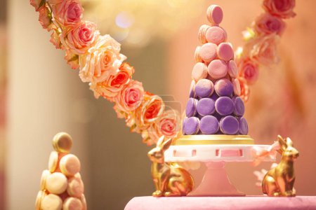 Téléchargez les photos : Pyramide, cône en macarons français sur assiette de gâteau piédestal, décoré de roses. Fenêtre de la boutique sucrée. Ferme là. Plan intérieur - en image libre de droit