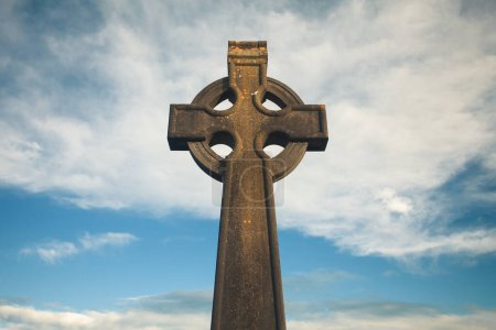 Téléchargez les photos : Irish Culture, Travel concept. Stone monument of Christian Cross in Bruff, County Limerick, Ireland. Blue sky background. Copy-space. Outdoor shot - en image libre de droit