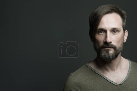 Photo for Mature men beauty concept. Portrait of an active 40-year-old man standing over dark gray background. Close up. Rocker, biker style. Scar on forehead. Copy-space. Banner style. Studio shot - Royalty Free Image