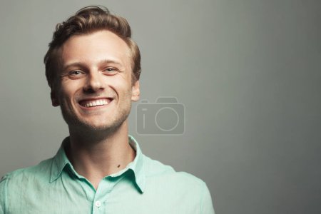Photo for Male beauty, boy next door concept. Portrait of laughing 30-year-old man standing over gray background. Close up. Classic style. Wavy glossy blond hair. Copy-space. Studio shot - Royalty Free Image