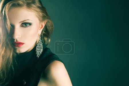 Hochmodisches Konzept. Porträt der schönen Mode rothaarige Supermodel posiert über dunkelsmaragdgrünen Hintergrund. Schönheitskampagnenstil. Aus nächster Nähe. Kopierraum. Studioaufnahme