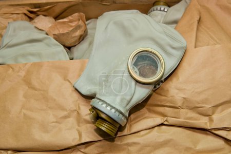 Téléchargez les photos : Masque à gaz soviétique dans une boîte en bois. Entrepôt d'équipement de protection soviétique. Gros plan. - en image libre de droit