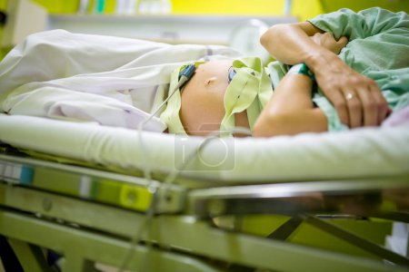 Foto de Vista de ángulo bajo de una mujer embarazada acostada en una cama de hospital con monitor de frecuencia cardíaca del bebé conectado a su gran vientre hinchado. - Imagen libre de derechos