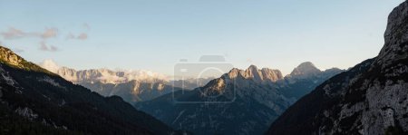 Foto de Imagen de vista amplia de hermosas montañas de roca alta con picos iluminados por el sol poniente. - Imagen libre de derechos