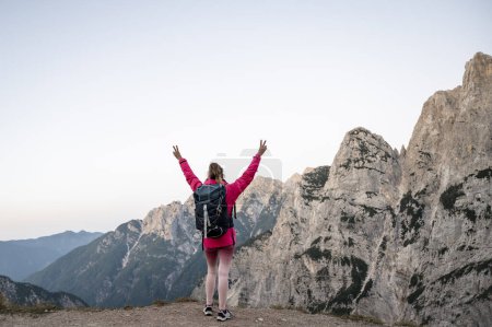 Foto de Mujer feliz senderismo en paisaje montañoso escénico, de pie con los brazos en alto. - Imagen libre de derechos