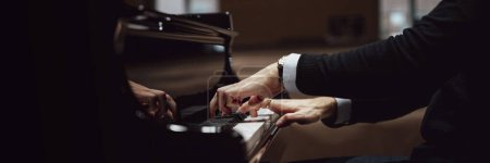 Foto de Vista amplia de la imagen de manos masculinas en traje elegante tocando el piano de concierto negro. Vista de cerca. - Imagen libre de derechos