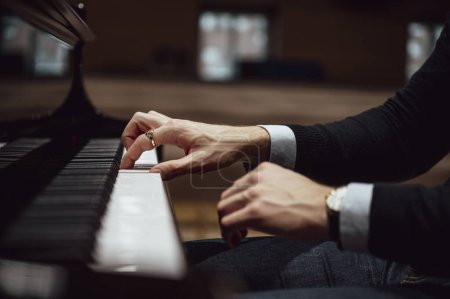Foto de Vista de primer plano de bajo ángulo de manos pianistas en traje elegante tocando el piano. - Imagen libre de derechos