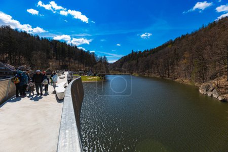 Foto de Zagorze Slaskie, Polonia - Abril 2022: Hermoso paisaje del lago Bystrzyckie y colinas alrededor vistas desde una pequeña pasarela sobre el lago - Imagen libre de derechos