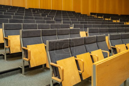 Téléchargez les photos : Wroclaw, Poland - May 2022: Interior of big conference hall of Wroclaw University of Science and Technology full of gray folding chairs and wooden walls - en image libre de droit