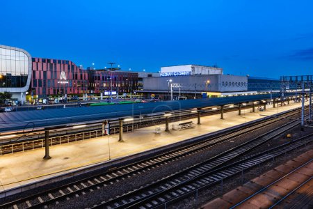 Foto de Poznan, Polonia - Julio 2022: Vista superior de la estación principal con pistas, plataforma, edificio de la estación y centro comercial "Avenida" en la noche - Imagen libre de derechos