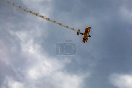 Téléchargez les photos : Leszno, Pologne - 16 juin 2023 : Antidotum Airshow Leszno 2023 et spectacles acrobatiques de Boeing Stearman jaune sur un ciel nuageux bleu - en image libre de droit