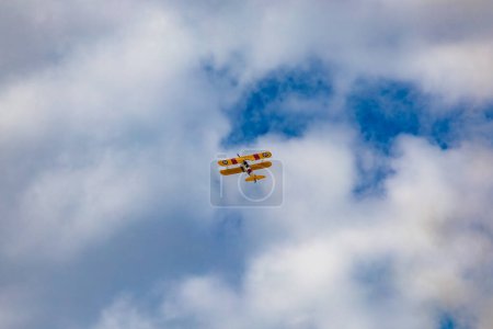 Téléchargez les photos : Leszno, Pologne - 16 juin 2023 : Antidotum Airshow Leszno 2023 et spectacles acrobatiques de Boeing Stearman jaune sur un ciel nuageux bleu - en image libre de droit