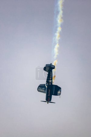 Photo for Leszno, Poland - June 16 2023: Antidotum Airshow Leszno 2023 and acrobatic shows full of smoke of Red Bull F4U Corsair on a cloudy sky - Royalty Free Image
