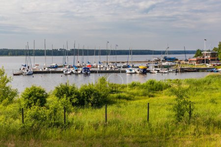 Téléchargez les photos : Smardzewice, Pologne - 9 juin 2023 : Petite baie pleine de bateaux et de ferries sur la côte du grand lac au matin ensoleillé - en image libre de droit