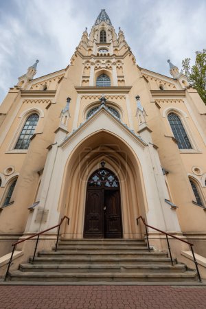 Warsaw, Poland - October 15 2023: Beautiful facade of high evangelical reformed church with high tower and big wooden doors 