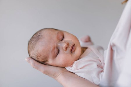 Photo for Portrait of baby sweet sleeping on mothers hands. Loving mom carying of her newborn baby at home. Mother hugging her little 1 months old girl. - Royalty Free Image