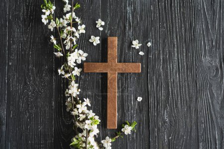 Photo for Cross symbolizing the death and resurrection of Jesus Christ, spring flowers on a wood background - Royalty Free Image