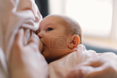 Photo for Newborn baby girl sucking milk from mothers breast. Portrait of mom and breastfeeding baby. Concept of healthy and natural baby breastfeeding nutrition. - Royalty Free Image