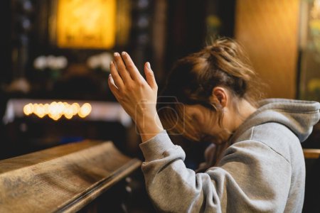 Foto de Mujer orando de rodillas en un antiguo templo católico a Dios. Manos dobladas en concepto de oración por la fe, la espiritualidad y la religión. Paz, esperanza, concepto de sueños - Imagen libre de derechos