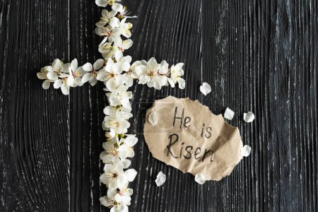 Photo for Cross with flowers on a wooden background with the inscription Christ is Risen. Easter concept. Cross symbolizing the death and resurrection of Jesus Christ - Royalty Free Image