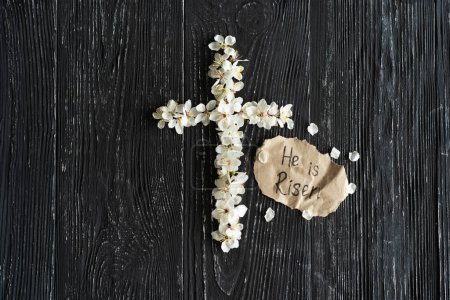 Photo for Cross with flowers on a wooden background with the inscription Christ is Risen. Easter concept. Cross symbolizing the death and resurrection of Jesus Christ - Royalty Free Image