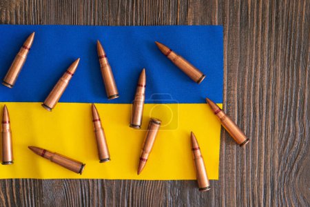 Téléchargez les photos : Plusieurs douilles de balles sont soigneusement disposées sur le drapeau bleu-jaune de l'Ukraine. Guerre en Ukraine. Le concept de l'assistance en matière d'armes à l'Ukraine - en image libre de droit
