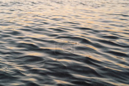 Wellen erzeugen ein beruhigendes und rhythmisches Muster. Das Wasser reflektiert den Himmel, wobei die Bewegung der Wellen der Oberfläche Struktur verleiht.