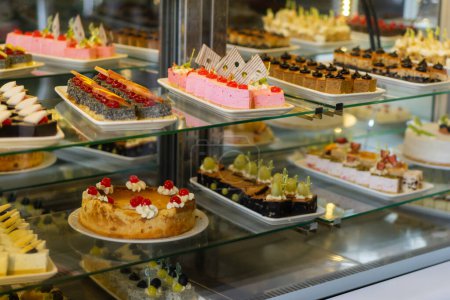 Vitrine avec des bonbons, Divers desserts et gâteaux à vendre dans la pâtisserie. Présentoir en verre au magasin boulangerie pâtisserie.