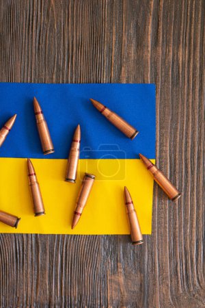 Varios casquillos de bala están perfectamente dispuestos en la bandera azul-amarilla de Ucrania. Guerra en Ucrania. El concepto de asistencia armamentística a Ucrania
