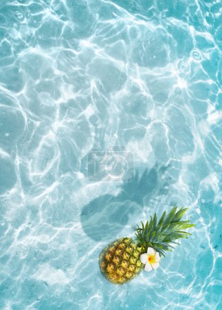 Photo for Yellow pineapple and white flower on a blue water background. Exotic concept. - Royalty Free Image