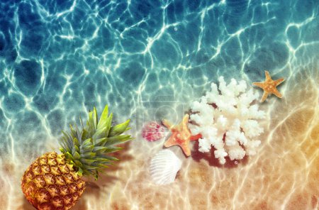 Foto de Piña amarilla, conchas marinas y estrellas de mar sobre un fondo de agua azul. Concepto exótico. - Imagen libre de derechos