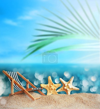 Foto de Tumbona, estrella de mar y palmera en la playa de arena. Hora de verano. Concepto de verano. - Imagen libre de derechos