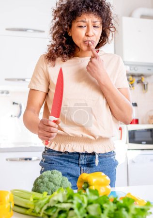 Photo for Careless black woman injury at home with kitchen knife - Royalty Free Image