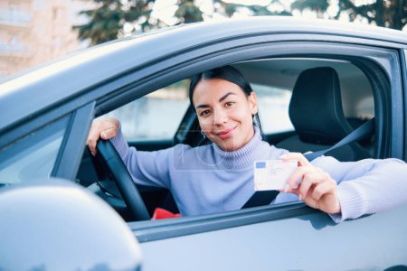 Una chica feliz sosteniendo su permiso de conducir