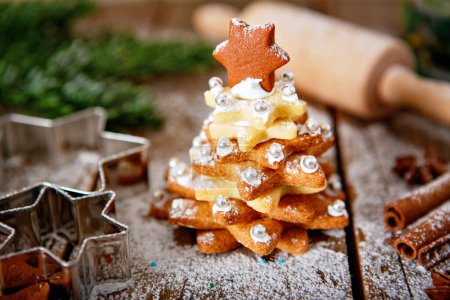 Photo for Home made baked Christmas gingerbread tree as a gift for family and friends on wooden background. With colorful lights from Christmas tree on background. With icing sugar gift for xmas. - Royalty Free Image