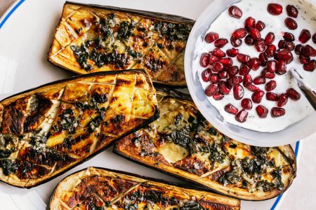 Photo for Grilled eggplants with garlic yogurt sauce, walnuts and pomegranate, vegan food - Royalty Free Image