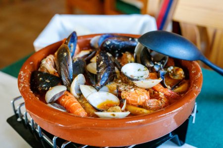 Traditional Spanish seafood zarzuela - stewed fish fillets, sea molluscs and crustaceans in thick sauce.