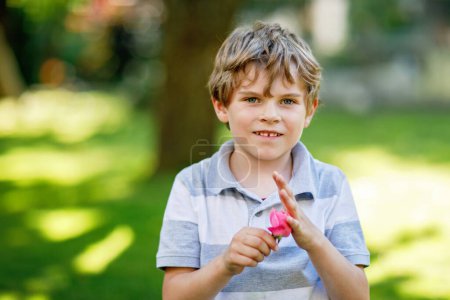 Téléchargez les photos : Happy little kid boy smiling. Portrait of young boy in nature, park or outdoors - en image libre de droit